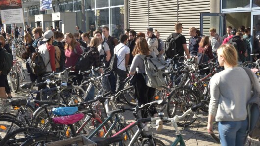 Zwischen abgestellten Fahrrädern drängen sich Studierende der FSU zu Beginn der Vorlesungszeit